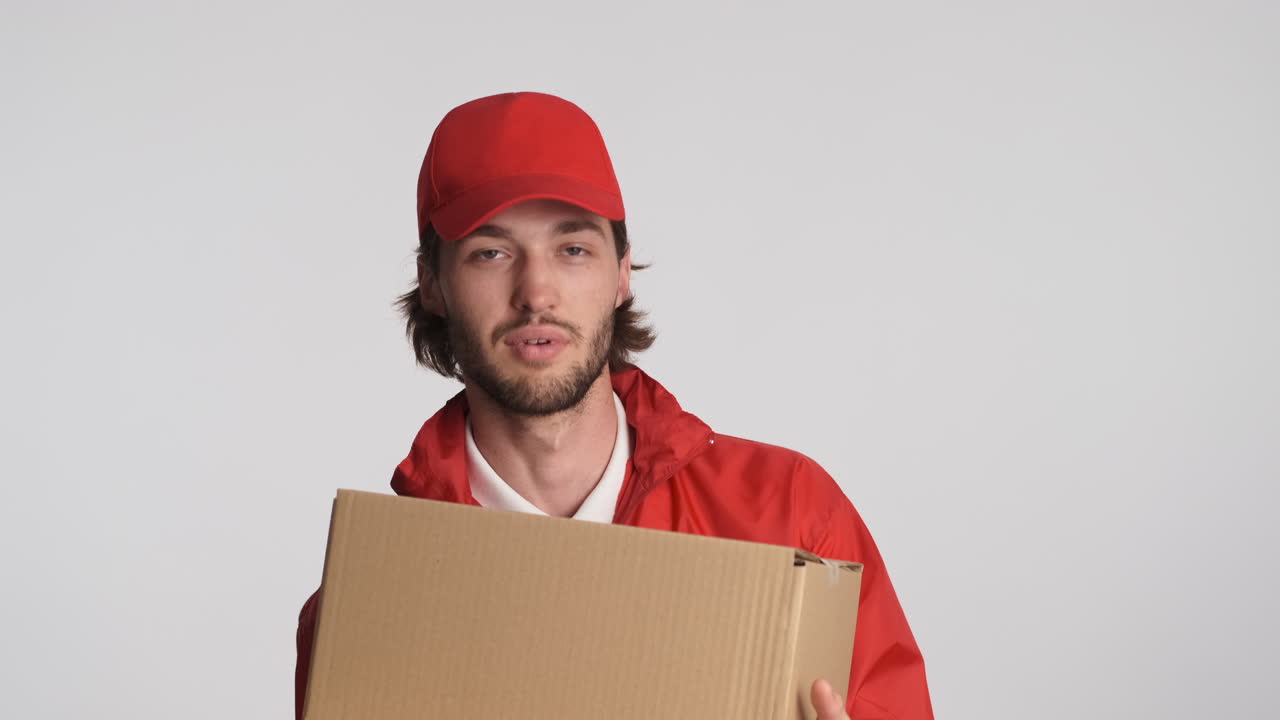 Caucasian delivery man in front of camera on white background.
