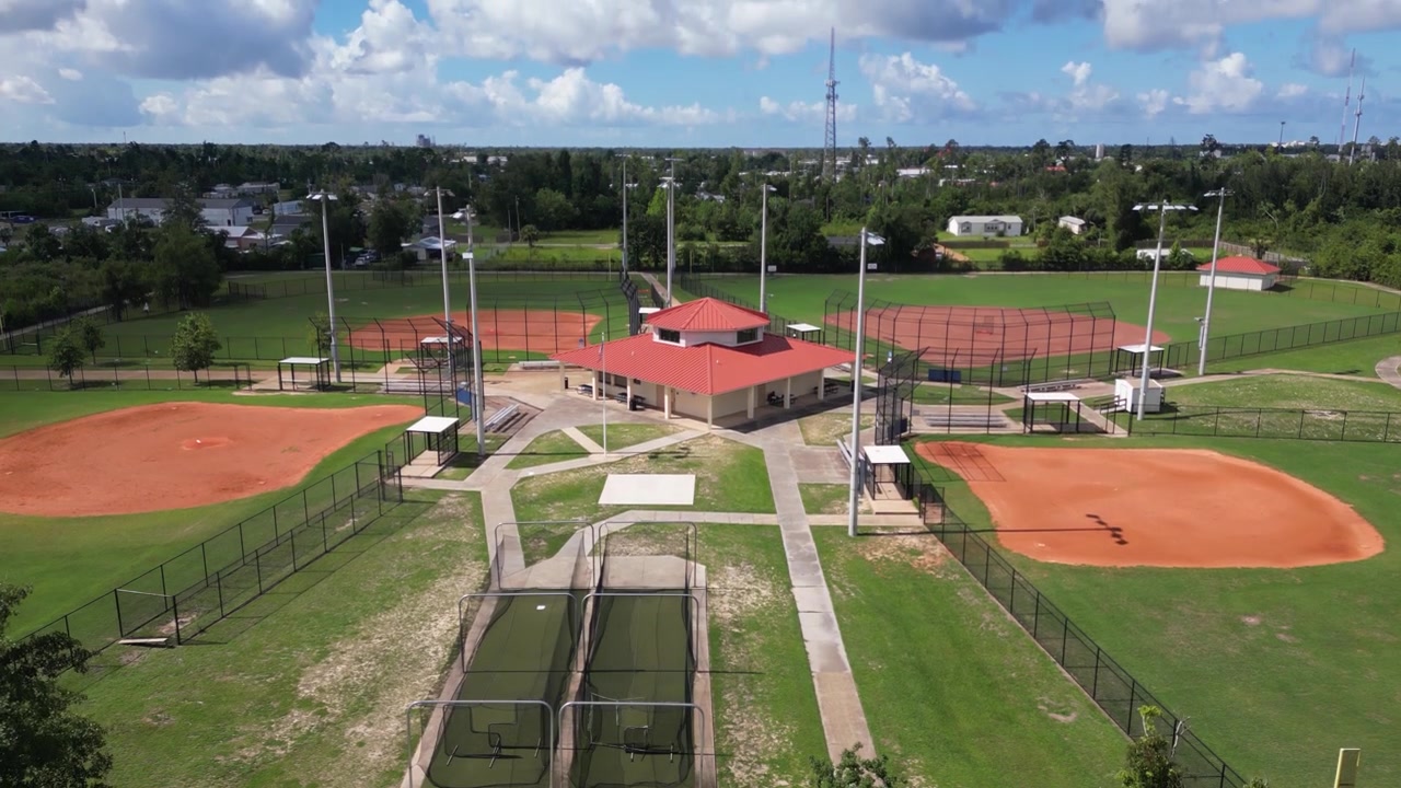 Toma de dron descendente de campos de béisbol y un edificio de concesiones en un pequeño parque deportivo