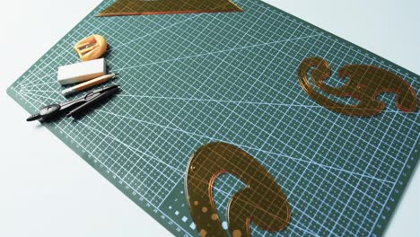 compass, pencil, sharpener, eraser and rulers with pad on white background, in slow motion