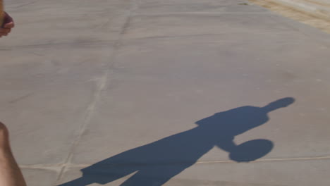 medium shot of a silhouette of a young man playing alone on a basketball court in a street court in barcelona, spain