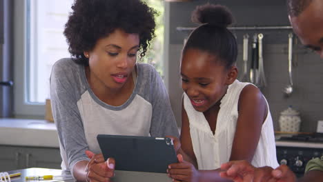 Mother-Helping-Daughter-With-Homework-In-Kitchen