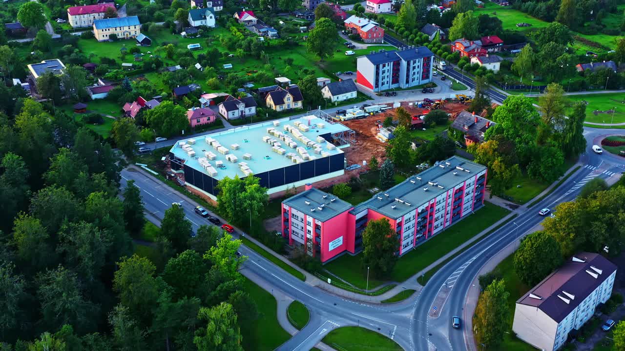 Aerial view of small town with new commercial building construction among homes in Smiltene, Latvia