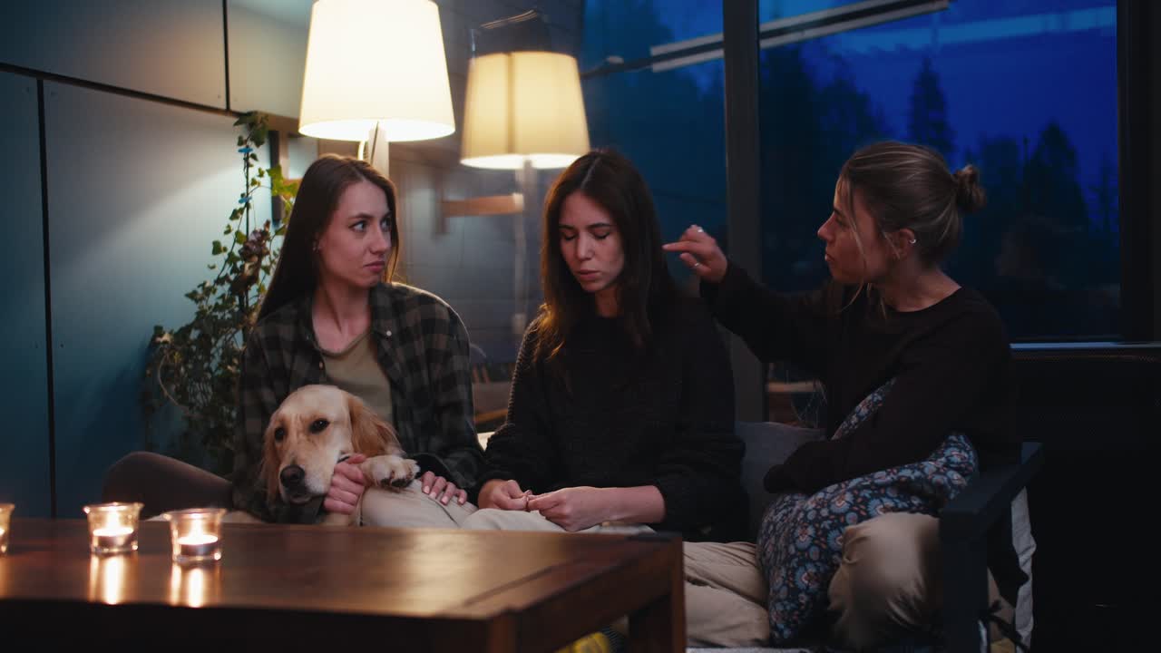 세 명의 소녀들이 데반에 앉아서 소통합니다. 갈색 소녀는 친구들에게 자신의 경험에 대해 이야기합니다. 그들은 그녀를 지원합니다.