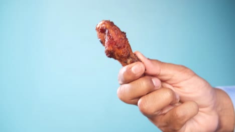 mano con un delicioso ala de pollo frito