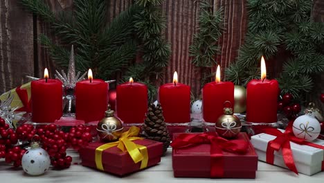 red christmas candles and christmas gif boxes against wooden background