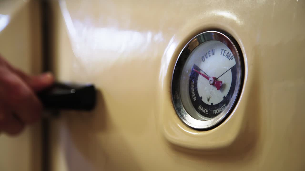 온도 게이지 4k가 있는 레이번 빈티지 오븐 도어를 손으로 엽니다.