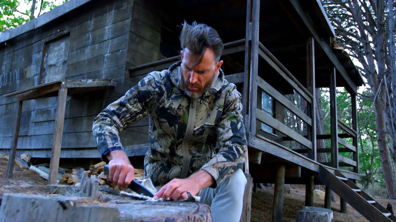 hombre modelando la piel de un animal en el bosque 4k