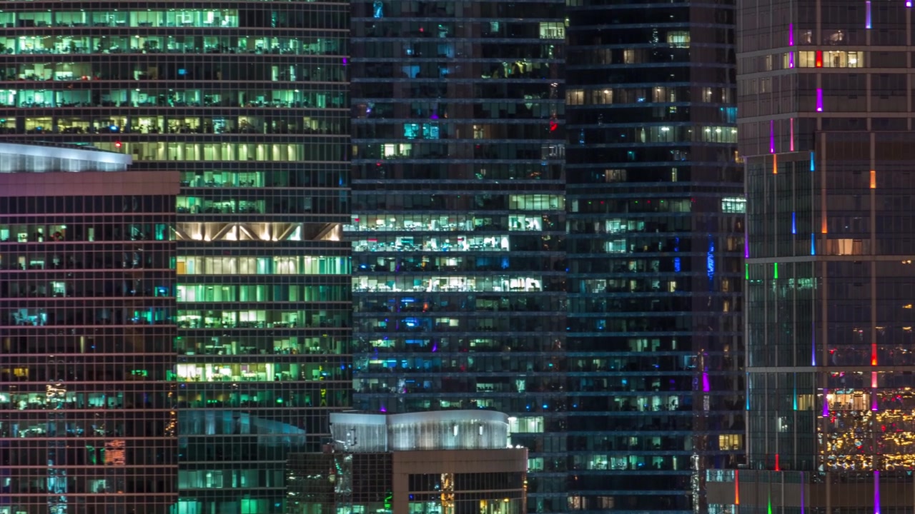 Modern office building with glowing windows at night timelapse. Moscow city. Close up view from rooftop