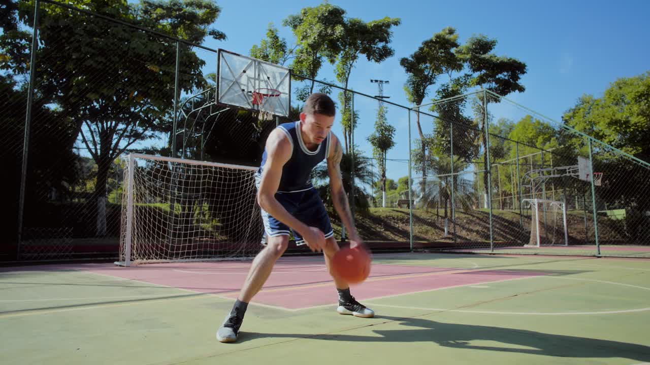 Man Dribbling Basketball on an Outdoor Court