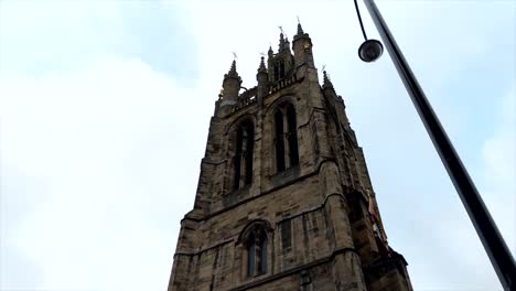 glide video of an old english church tower in a cloudy day