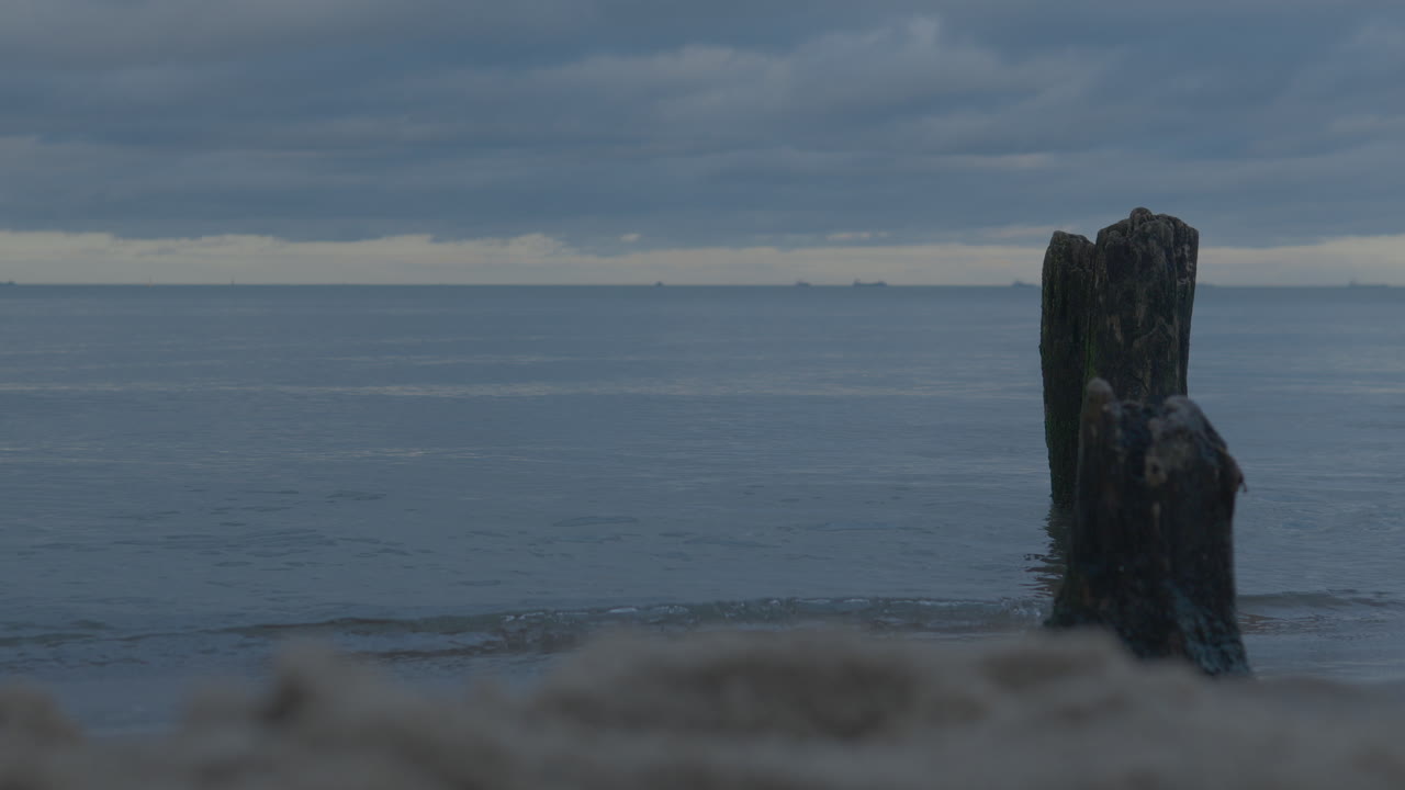 postes de madera del rompeolas cerca de la orilla, amplio horizonte con vistas al mar