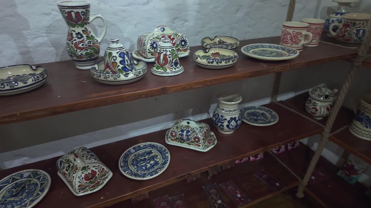 Collection of artistic folk-patterned ceramic mugs and bowls on display in Sighișoara, Romania