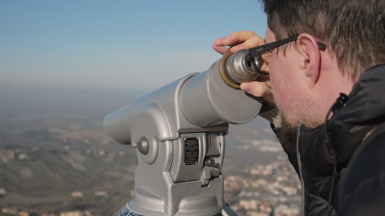 hombre usando un telescopio para ver un paisaje