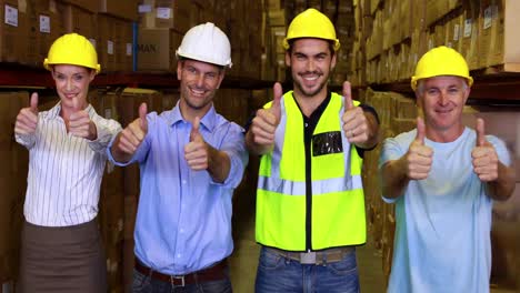 warehouse team smiling and showing thumbs up together