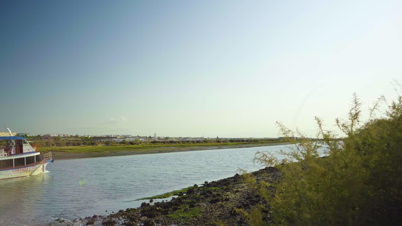 la orilla del río por la mañana con el transbordador pasando por tavira portugal
