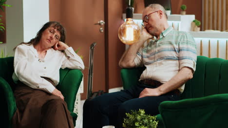 tired old people falling asleep on sofa