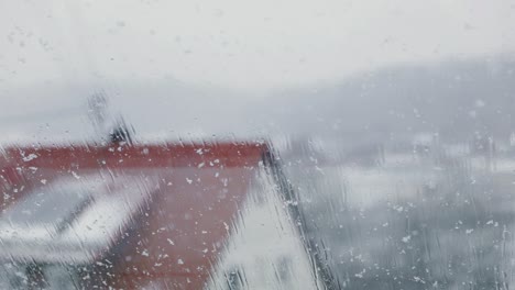 gloomy day with snowfall through window during winter. - slow motion