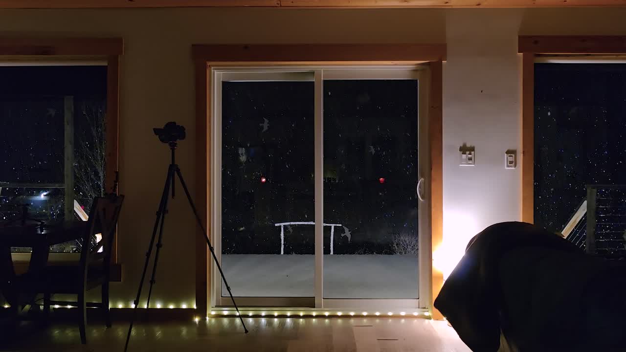 Cozy home interior at night while snowing outdoors, static view