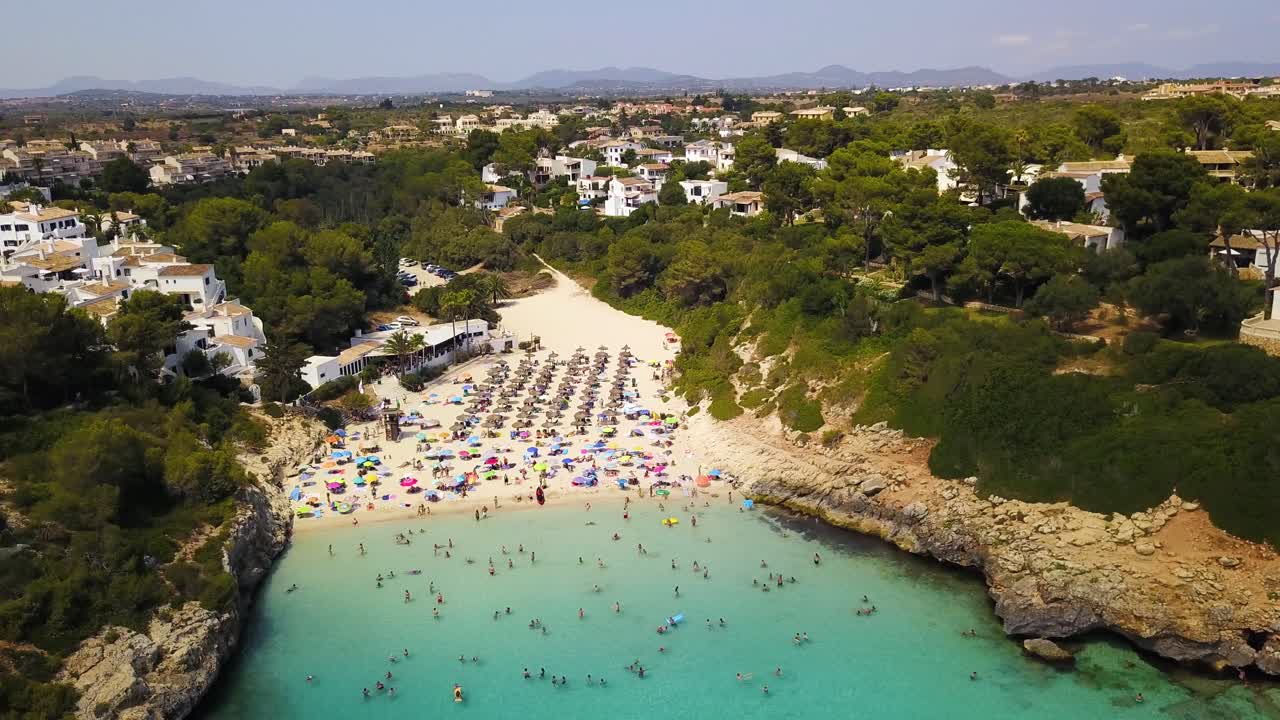 Spiaggia di Cala Anguila con bagnanti e nuotatori, acqua turchese vibrante, atmosfera estiva, Maiorca, vista aerea