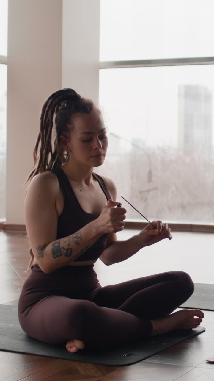 Woman meditating with incense in a yoga studio