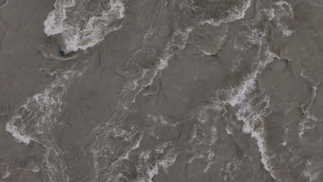 drone shot of monsoon flooding in nepal revealing rising water levels and powerful waves crashing against rocks captures massive force of nature due to heavy rain in critical landscape