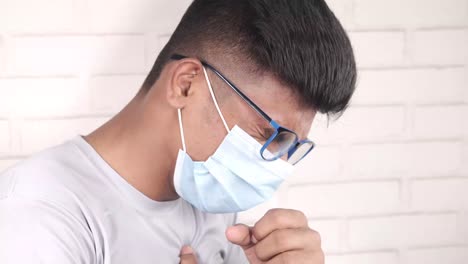 man coughing and wearing a mask