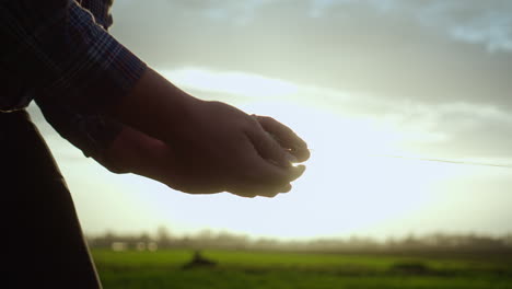 man holding in two hand a ball of string and starts to unroll the ball towards the bar, sun is shining in the background