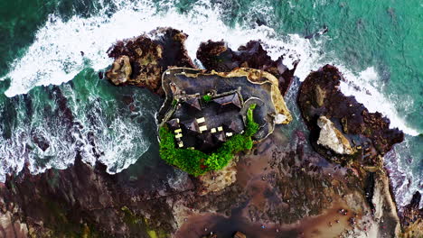 ancient mythical temple of tanah lot on rock above sea waves, bali