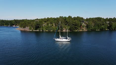 drone shows peaceful yacht in baltic inlet near trees in stockholm, sweden bay