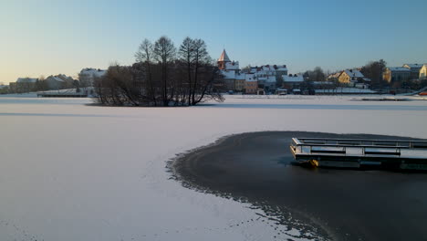 snowy and frozen lake with islet at dawn in gorowo ilaweckie, poland