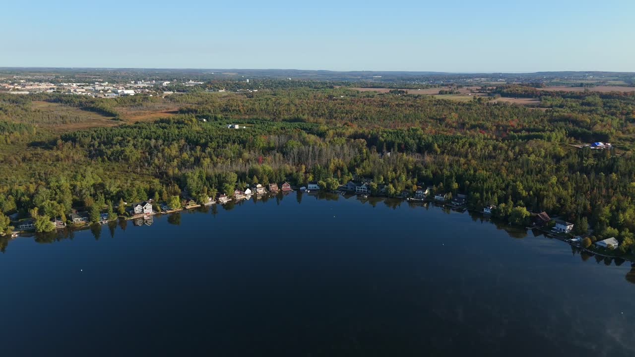 Serene Caledon Lake view with nearby cottages and town in the distance