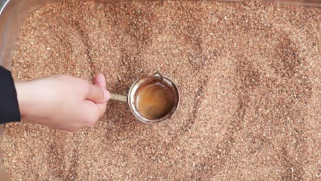 preparing turkish coffee in sand