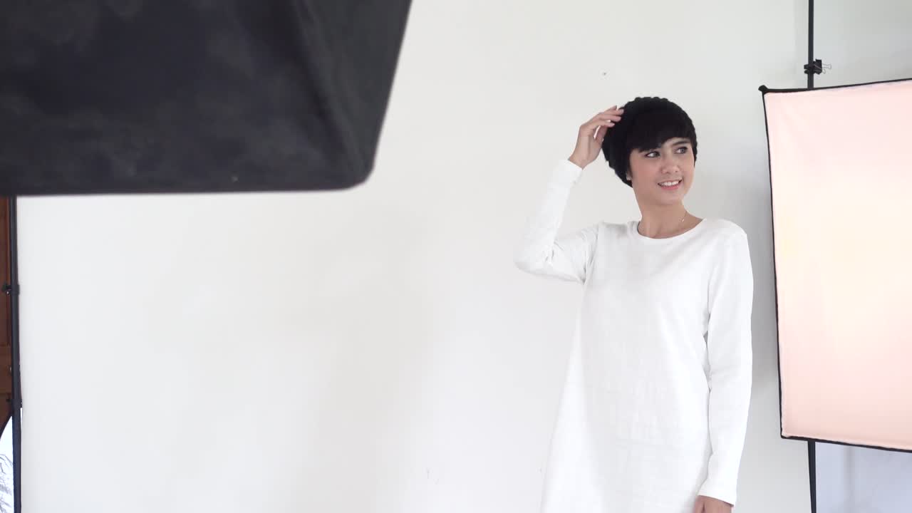 Behind the scenes on photo shoot, beautiful asian model posing for fashion catalog