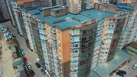 New apartment complex in the city. High-raised buildings near the road with moving cars. Modern infrastructure in downtown with car parking. Comfortable life in the city.