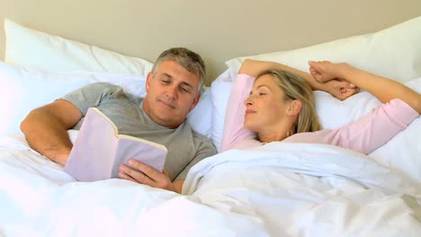 Pareja-Leyendo-Un-Libro-En-La-Cama