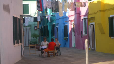ladies talking in burano village, venice, italy