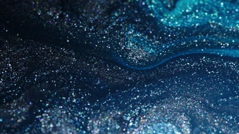 sparkling blue and silver particles swirl and blend in a mesmerizing macro shot