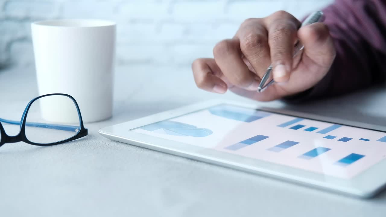 Person bruger tablet med grafer