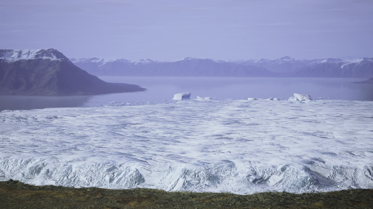 Glacial landscape with mountains and calm water on a clear day in greenland