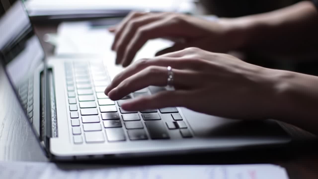 Focused Hands Typing on a Laptop Keyboard, Displaying the Intensity and Engagement of Digital Communication and Creative Work in a Cozy Workspace Environment