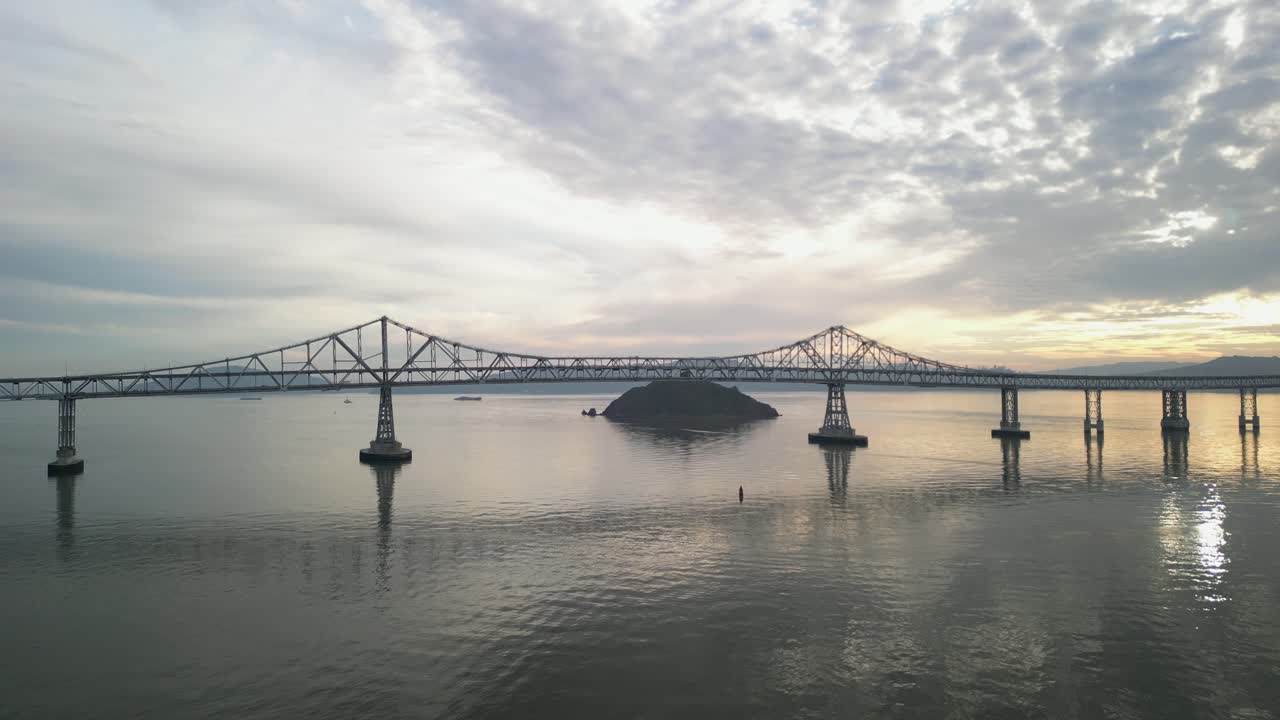 Serene symmetry of Richmond Bridge from Point Molate Beach Richmond California USA, backlit sunset