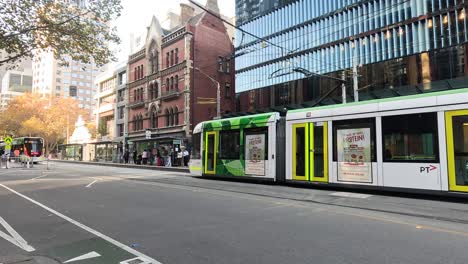 a tram moves through a busy melbourne street