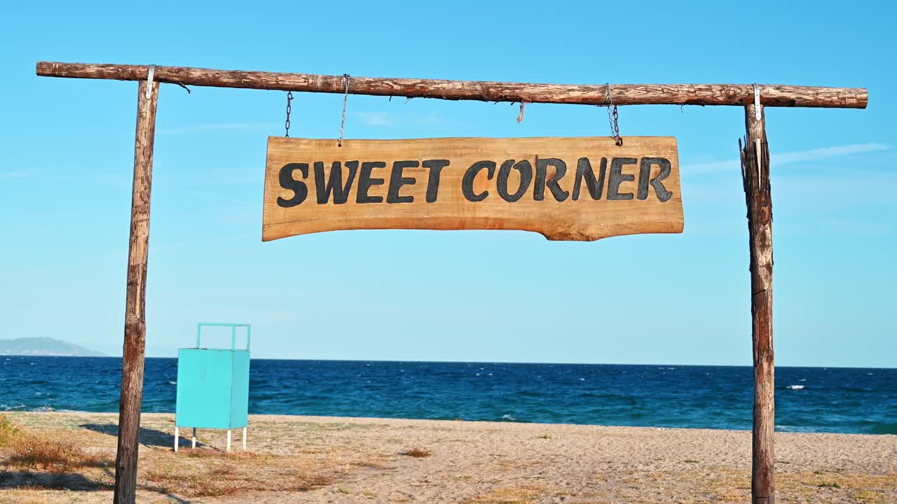 Sweet Corner sign made of wood on the beach with Aegean sea on the background, Olympiada, Greece