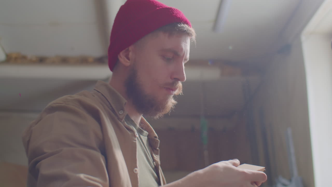 carpintero cortando una tabla de madera con una sierra de mitra