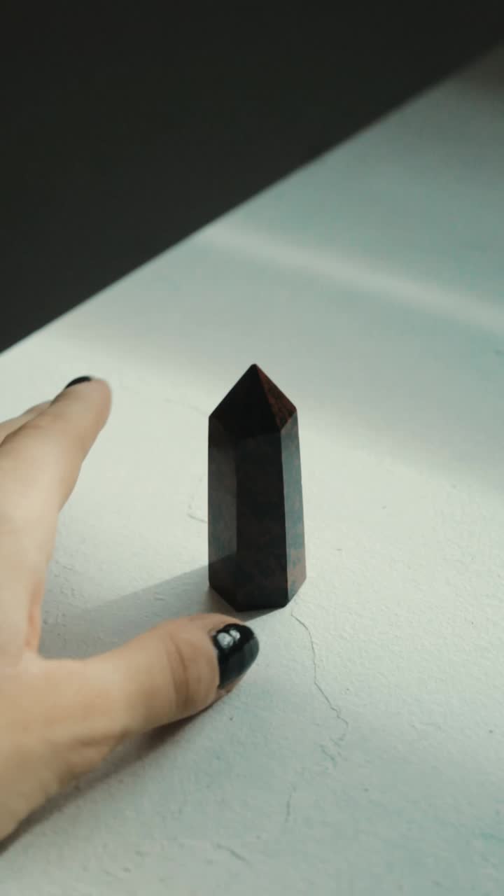 Hand Holding a Black Crystal Point