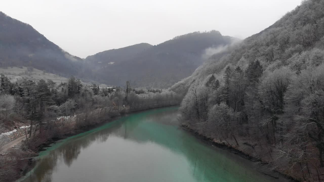 Kışın güzel bir nehrin üzerinde uçan dron, havada süzülen kar taneleri, soğuk bir sabah.