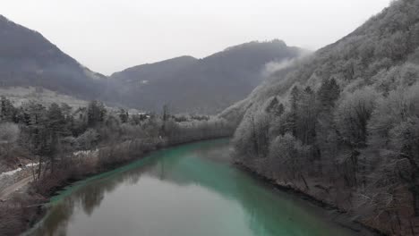 drone vuela sobre el hermoso río en invierno, copos de nieve bailando en el aire, mañana fría