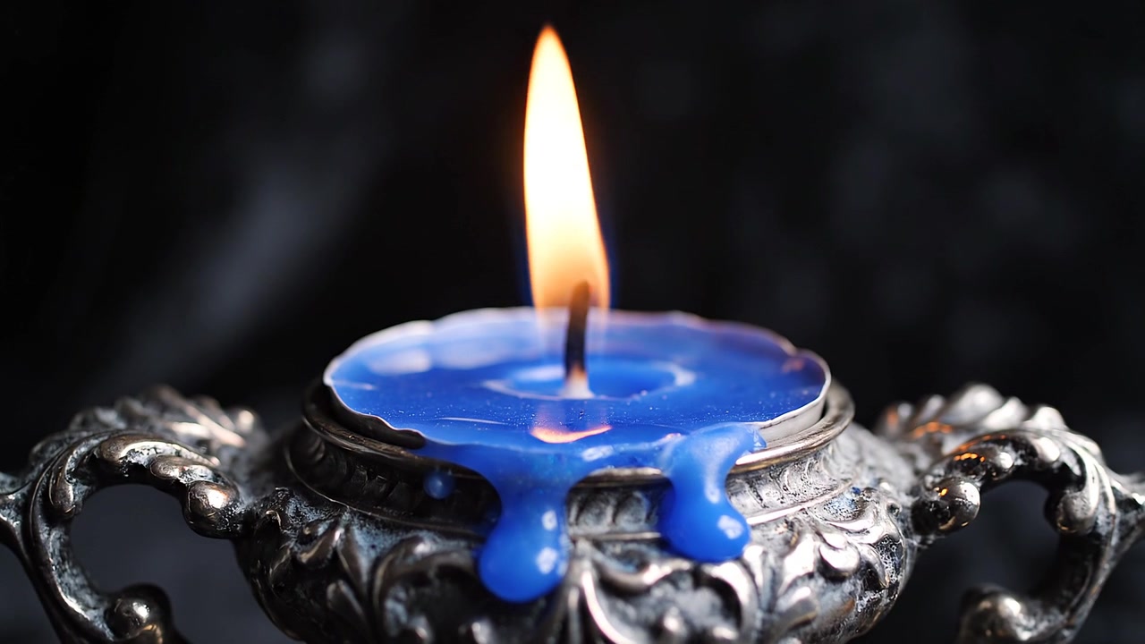Blue candle flame burning in vintage ornate silver holder