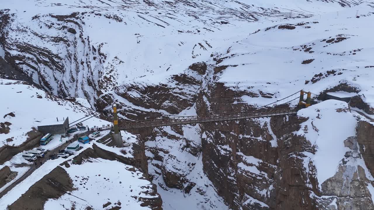 High-altitude Suspension Bridge in a Snowy Mountain Valley