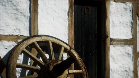 old wood wheel and black door at white house